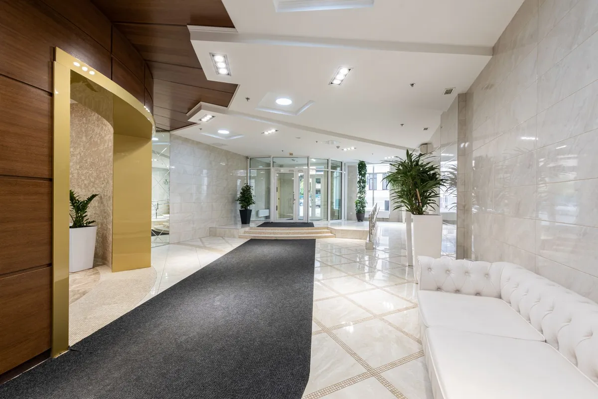Finished commercial lobby with polished tile flooring and an entrance mat